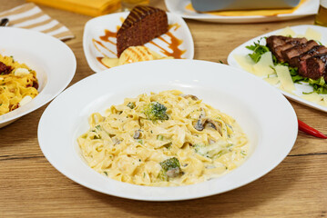 Hot dishes with pasta, cheese, vegetables and meat
