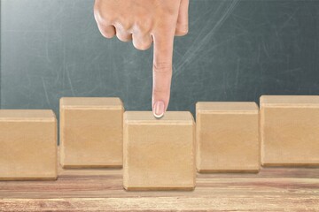 Hand  touching and push wooden cube block for creative and set up business objective concept.