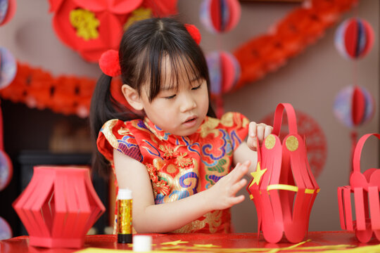 young Chinese girl making traditional Chinese "FU" means" lucky" Chinese lantern