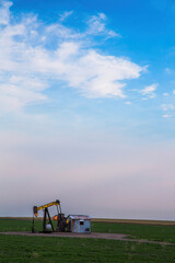 A working oil well pump in an agriculture field along highway 138 just before sunset near Sterling,...
