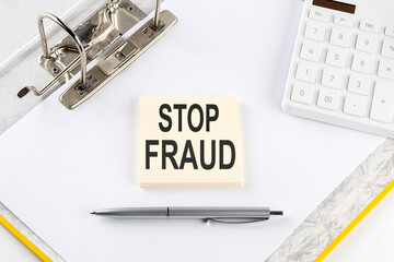 STOP FRAUD- business concept, message on the sticker on folder background with calculator