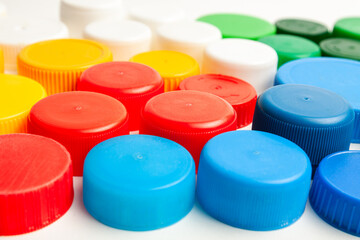 Colored plastic caps from bottles of water isolated on a white background. Close-up, top view....