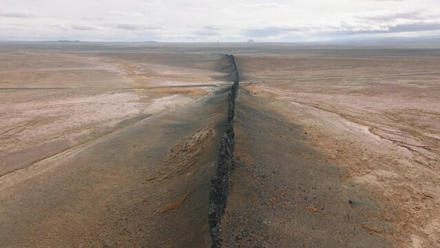 Barren terrain, formed by soil erosion, without vegetation under vivid skyline
