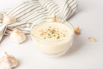 Bowl of Mayonnaise sauce on white wooden cutting board