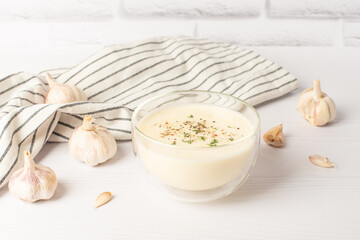 Bowl of Mayonnaise sauce on white wooden cutting board