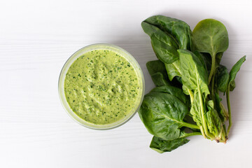 Delicious spinach sauce on a white table, flat lay. Place for text