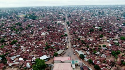 Doma community in Nassarawa State with birds flocking over the city center - aerial pull back flyover