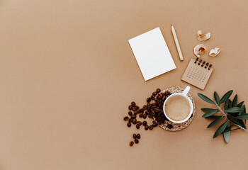Desktop mockup planner. Flat lay with calendar, blank card,  coffee cup and green olive leaves on...