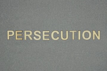 text on word persecution from wooden letters on a gray background
