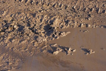 natural texture of brown clay and muddy dirty water on the road