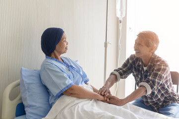 Obraz premium Senior man visiting cancer patient woman wearing head scarf at hospital, health care and medical concept