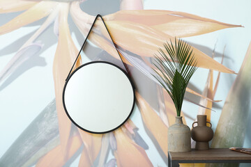 Stylish interior of room with mirror and beautiful strelitzia flowers on wall