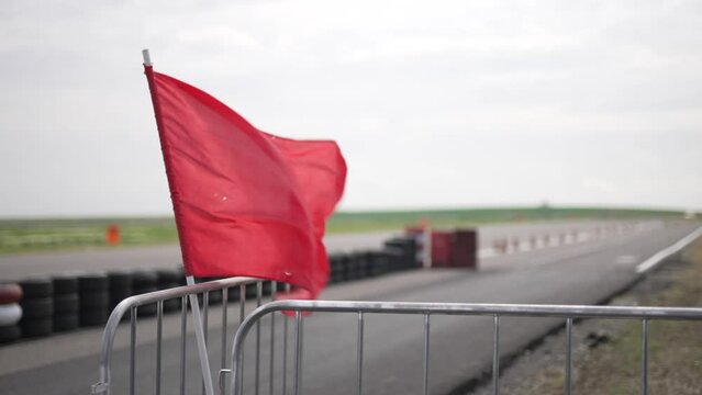 Red Flag waving in the wind on a Racing track; 100 fps slowed to 25