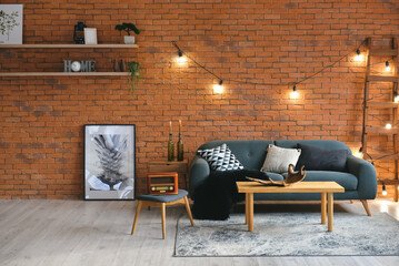 Stylish interior of living room with grey sofa, retro radio and brick wall