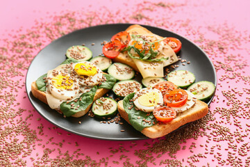 Plate with tasty toasts and flax seeds on color background
