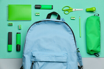 Set of different stationery with backpack on color background, closeup