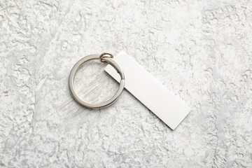 Stylish silver keychain on light background