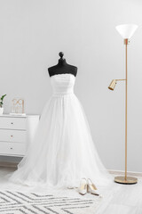 Mannequin with beautiful wedding dress prepared for ceremony in light room