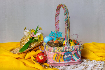 Fototapeta premium Easter basket with Easter decorations on a table and texture background