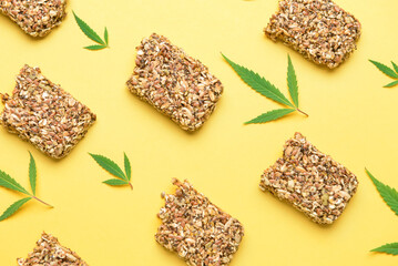 Protein bars with hemp seeds and leaves on yellow background