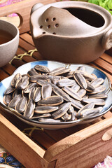 Sunflower seeds on a plate with hot tea  