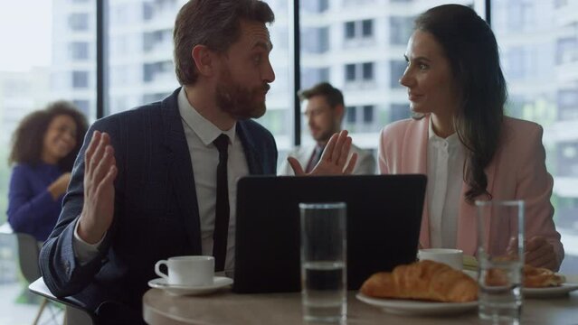 Motivated business group discuss project success using laptop computer in cafe.