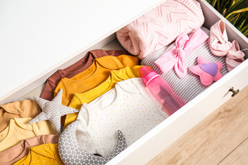 Drawer with baby clothes in children's bedroom