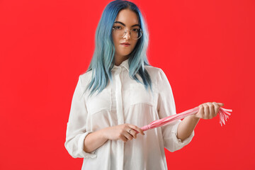 Young woman with whip from sex shop on red background - obrazy, fototapety, plakaty