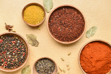 Bowls with different aromatic spices on color background, closeup