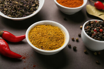 Bowls with aromatic spices on dark background, closeup