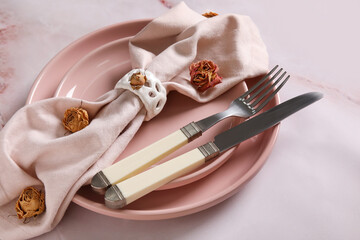 Stylish table setting with beautiful dried roses on light background, closeup