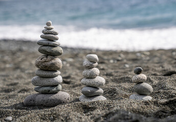 Stones stacked on the seashore under a blue sky.