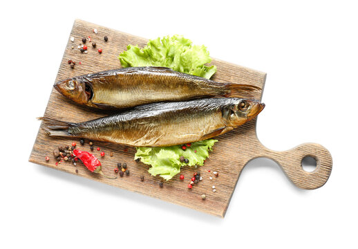 Wooden board with smoked herring fishes on white background
