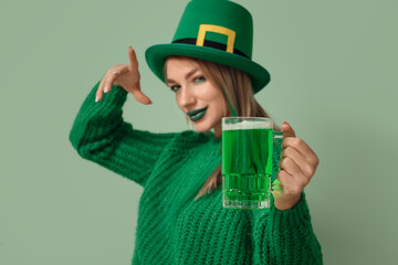 Beautiful woman in hat with glass of beer on green background, closeup. St. Patrick's Day...