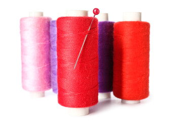 Different sewing threads with needle on white background