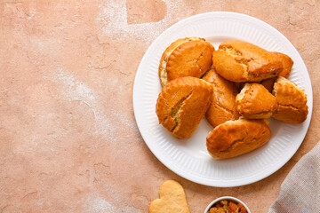 Plate of tasty sochniki with cottage cheese on beige background