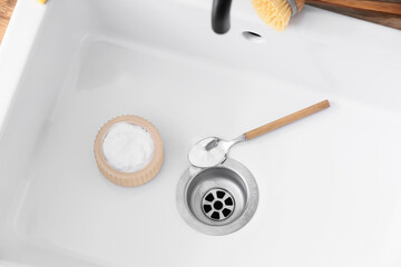 Spoon and cleaning powder on ceramic sink