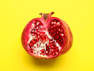 Ripe delicious pomegranate on yellow background