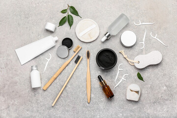 Composition with activated charcoal tooth powder, toothbrushes and floss toothpicks on grey...