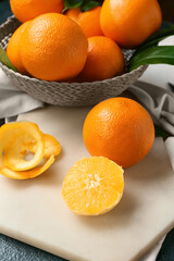 Board with fresh juicy oranges on table