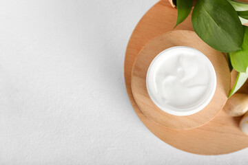 Jar with natural cosmetic cream on light background