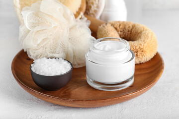 Fototapeta na wymiar Jar with natural cosmetic cream and sea salt on light background, closeup