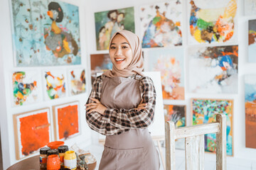 muslim female painter painting on canvas in her workshop