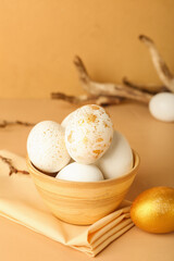 Bowl with Easter eggs on color background