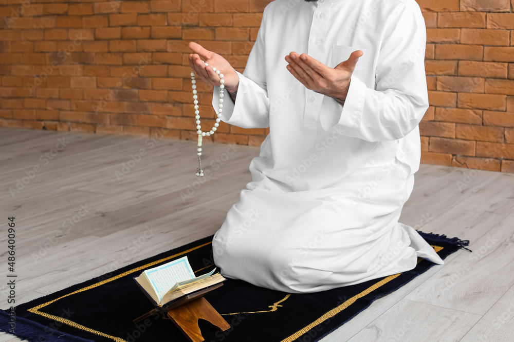 Wall mural praying young muslim man at home