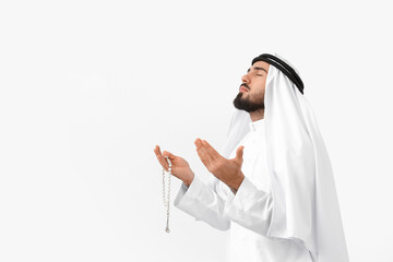 Praying young Muslim man on white background