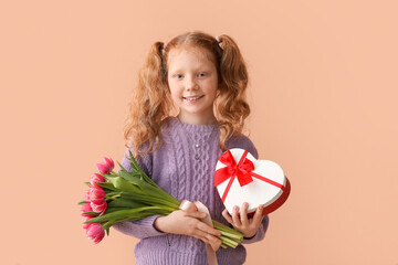 Little redhead girl with bouquet of tulips and gift box on beige background. International Women's Day