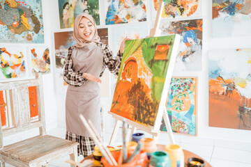 female painting artist showing and presenting her work