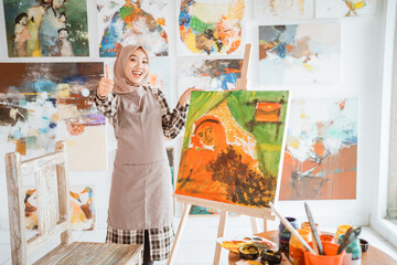 muslim asian female artist showing thumb up