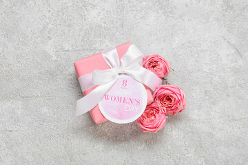 Card for International Women's Day, gift box and flowers on light background